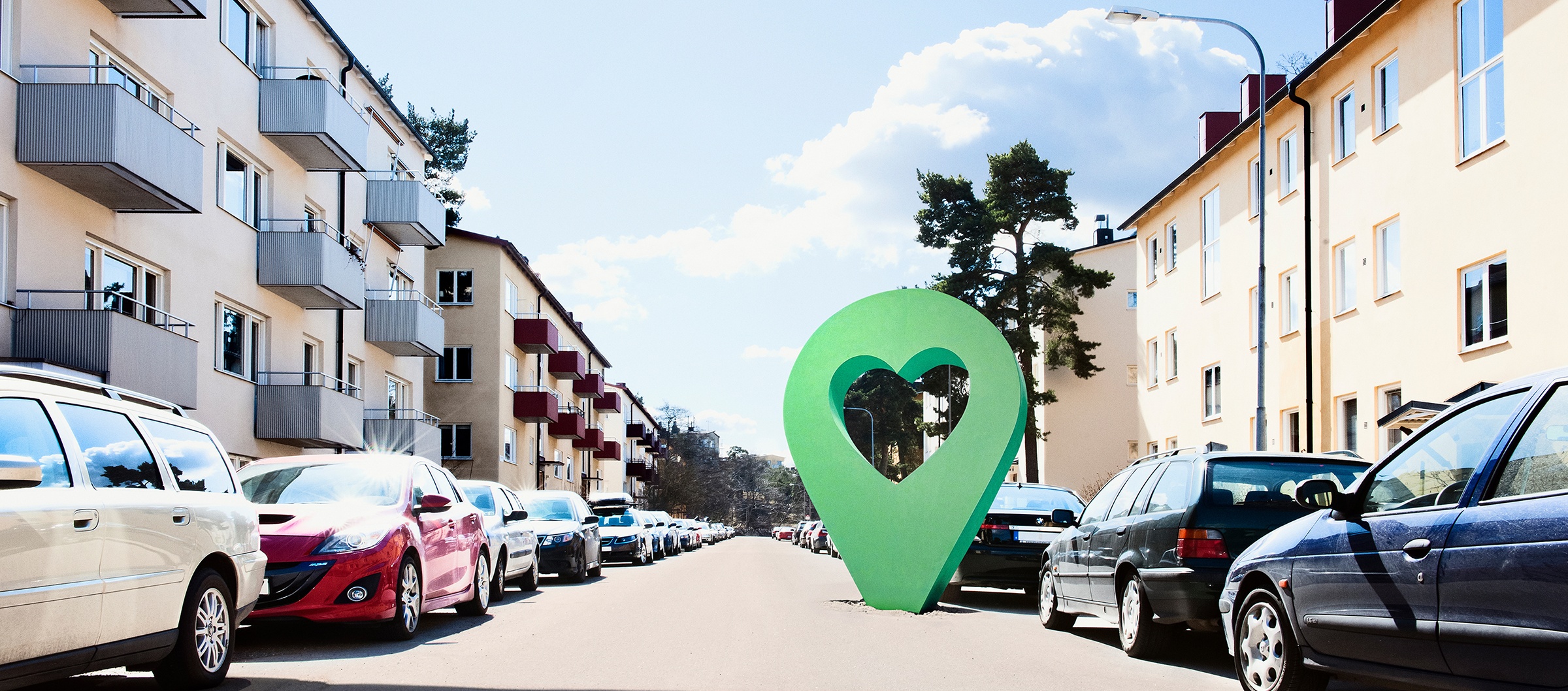 Lyckplatsen på bostadsgata Lyckplatsen symbol på en solig bostadsgata med parkerade bilar och flerfamiljshus.
