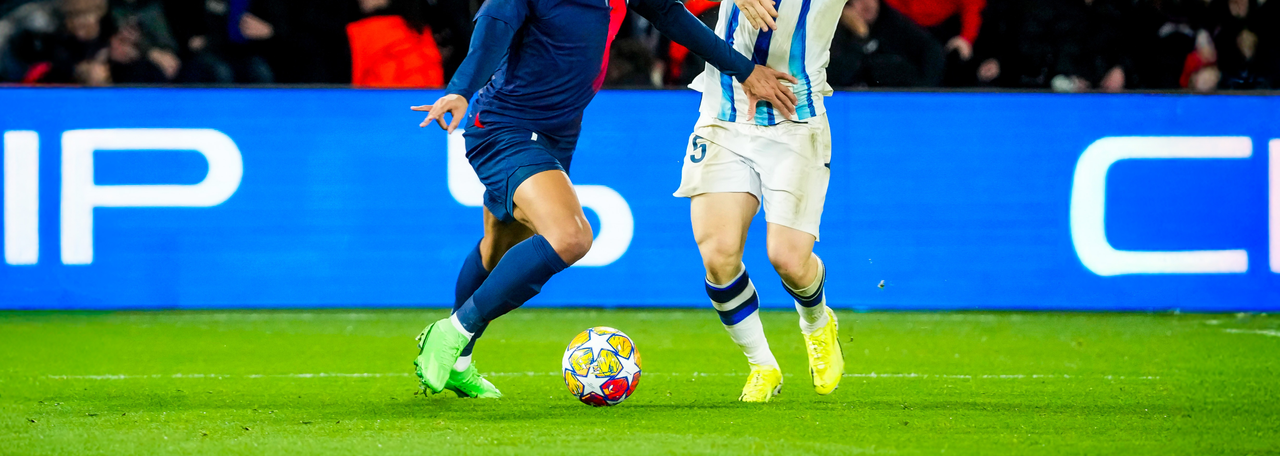 Champions League match mellan spelare i blå och vita tröjor och spelare i mörka blå tröjor