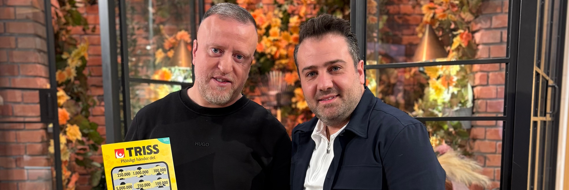 Trisskraparen Walid i tv-studion med sin vän Ghassan håller upp en Trisslott