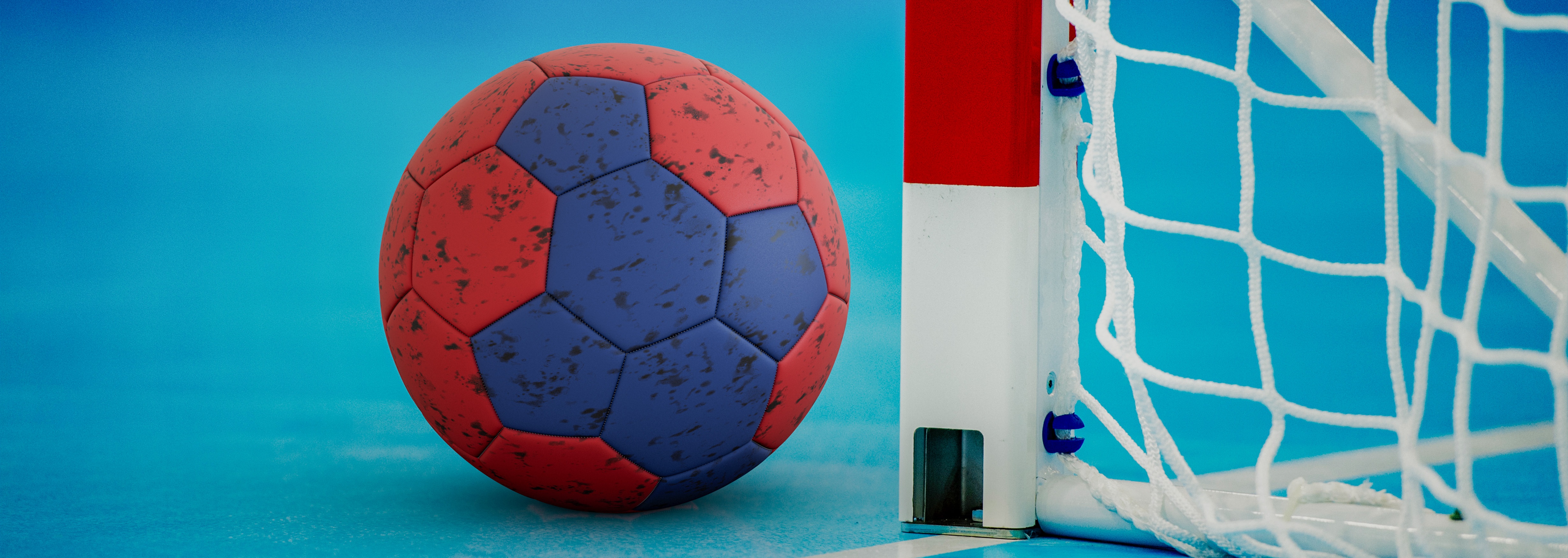 Handboll och mål på en blå spelplan under en handbollsmatch, fokus på bollen nära målstolpen.