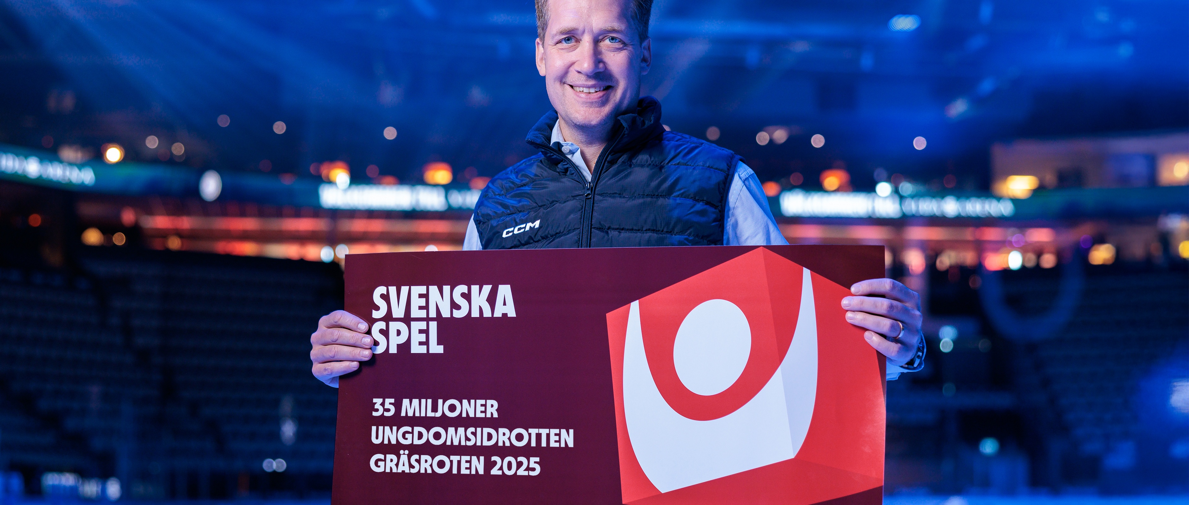 Sam Hallam håller i Svenska Spels Gräsroten-check 