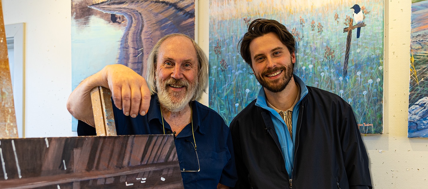 Två glada personer i en konststudio med tavlor i bakgrunden och texten 'Veckans lyckoplatser'.