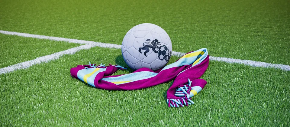 Bild på en fotboll och en supporterhalsduk med Premier League-laget Burnleys färger