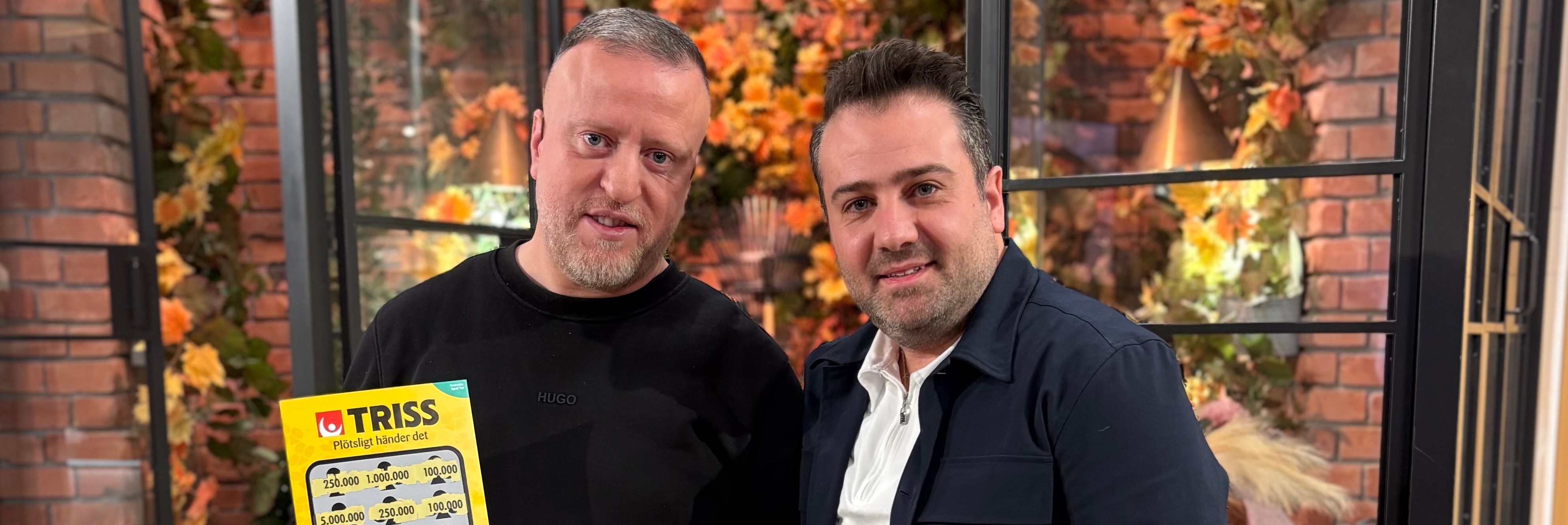 Trisskraparen Walid i tv-studion med sin vän Ghassan håller upp en Trisslott