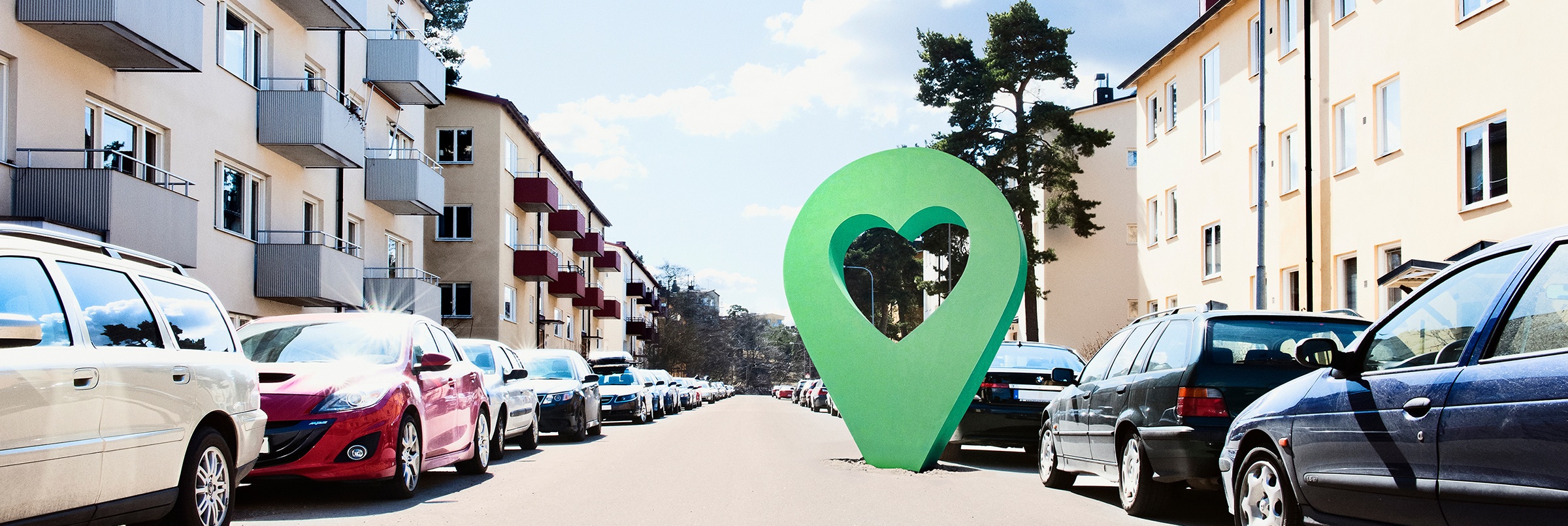 Lyckplatsen symbol på en solig bostadsgata med parkerade bilar och flerfamiljshus.