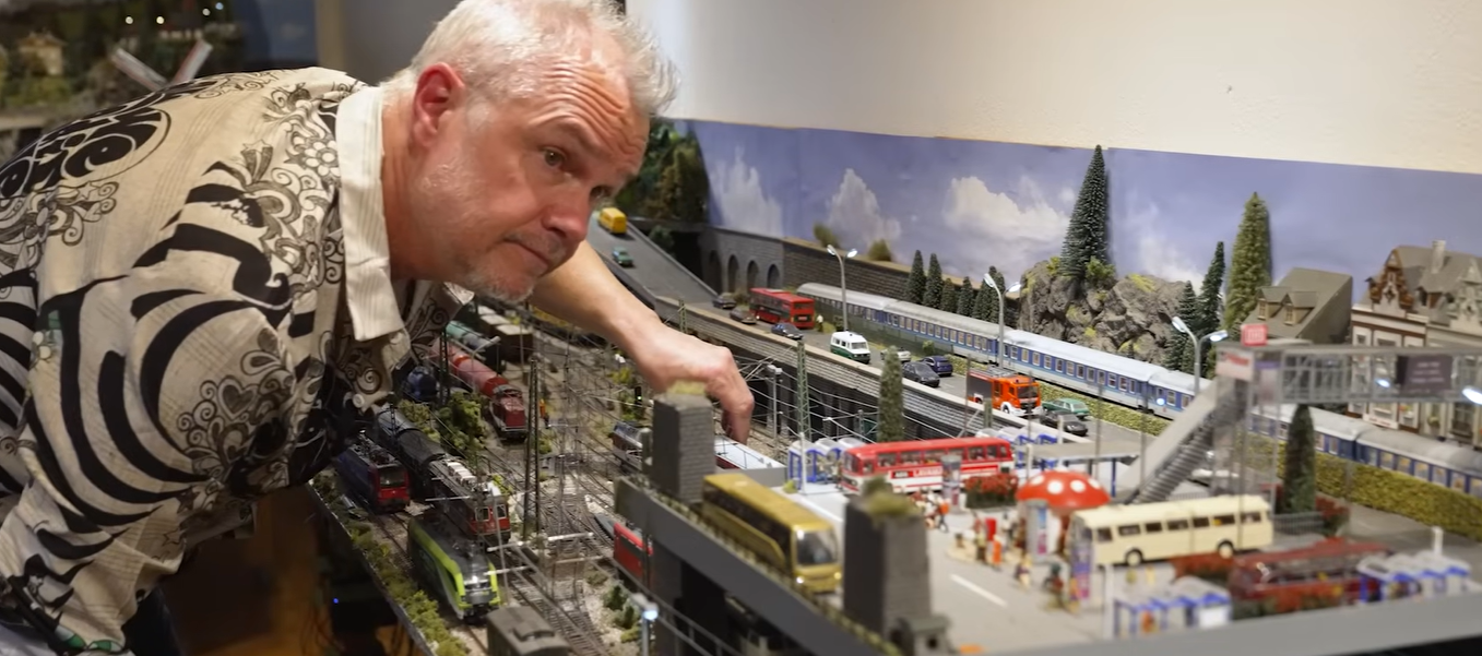 Danne står lutad över sin modelljärnväg hemma i Stuvsta